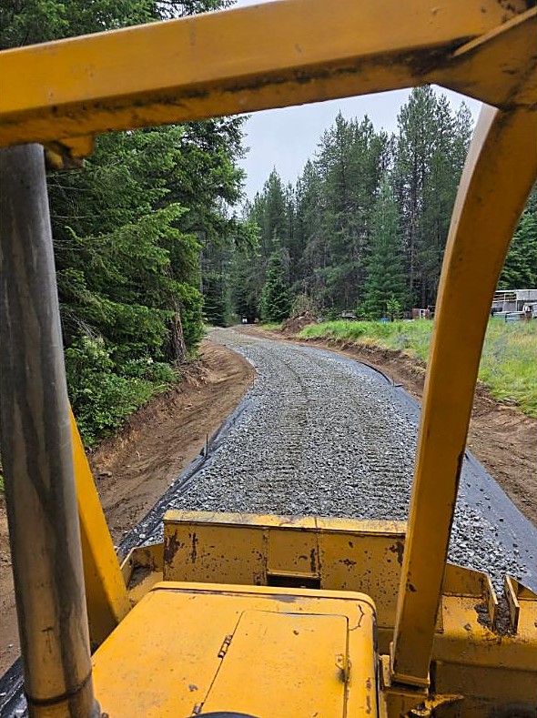 New gravel driveway curving through the pines